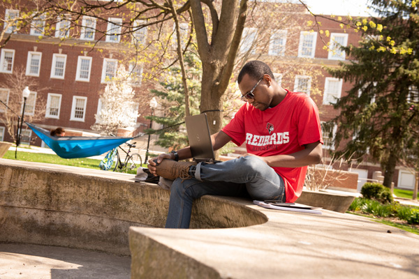 Male student studying on the quad.